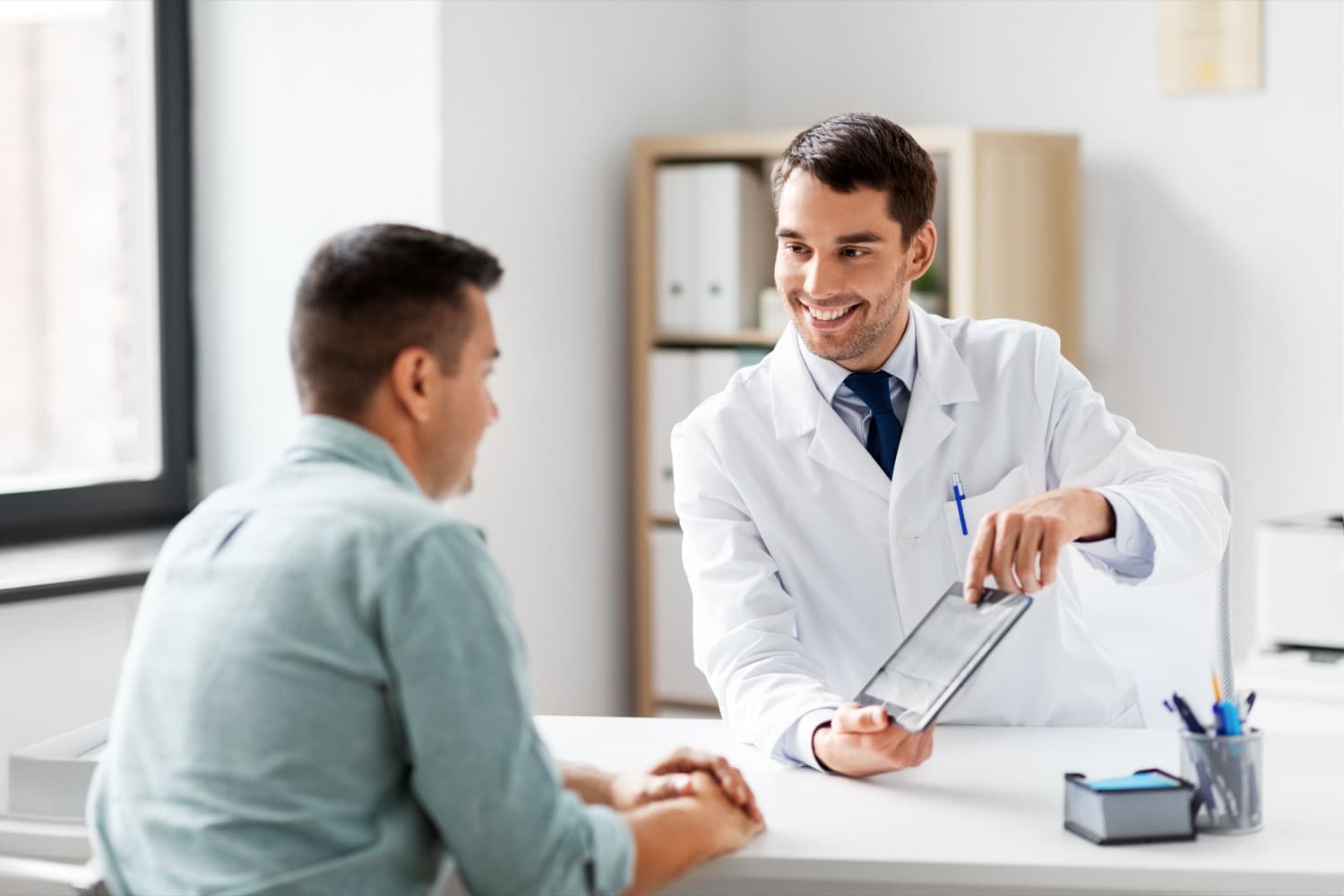 A clinician reviewing information with a patient on a tablet